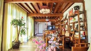 A cozy living room with wooden furniture, a television, and a bookshelf. - Lijiang Yuanshu Inn (Shuhe Ancient Town Branch) (Lijiang)