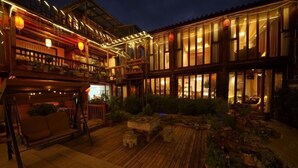 A traditional-style building with multiple levels, wooden balconies, and a courtyard with seating and plants. - Lijiang Yuanshu Inn (Shuhe Ancient Town Branch) (Lijiang)