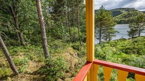 Une zone boisée avec une rambarde jaune et un lac en arrière-plan.