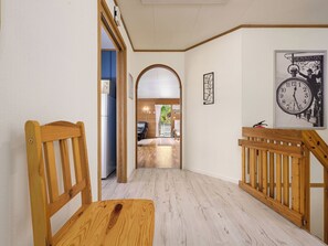 A hallway with wooden chairs, a wooden bench, a clock, and a framed picture on the wall. - Hovsfjellet by Interhome (Fresvik)