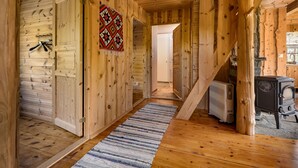 Een houten interieur met een gang, een radiator en een fornuis.