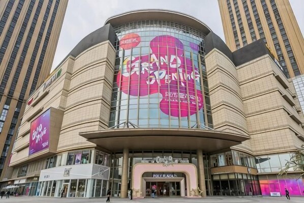 A modern building with a curved facade, large glass windows, and a prominent sign for 'Grand Opening.'