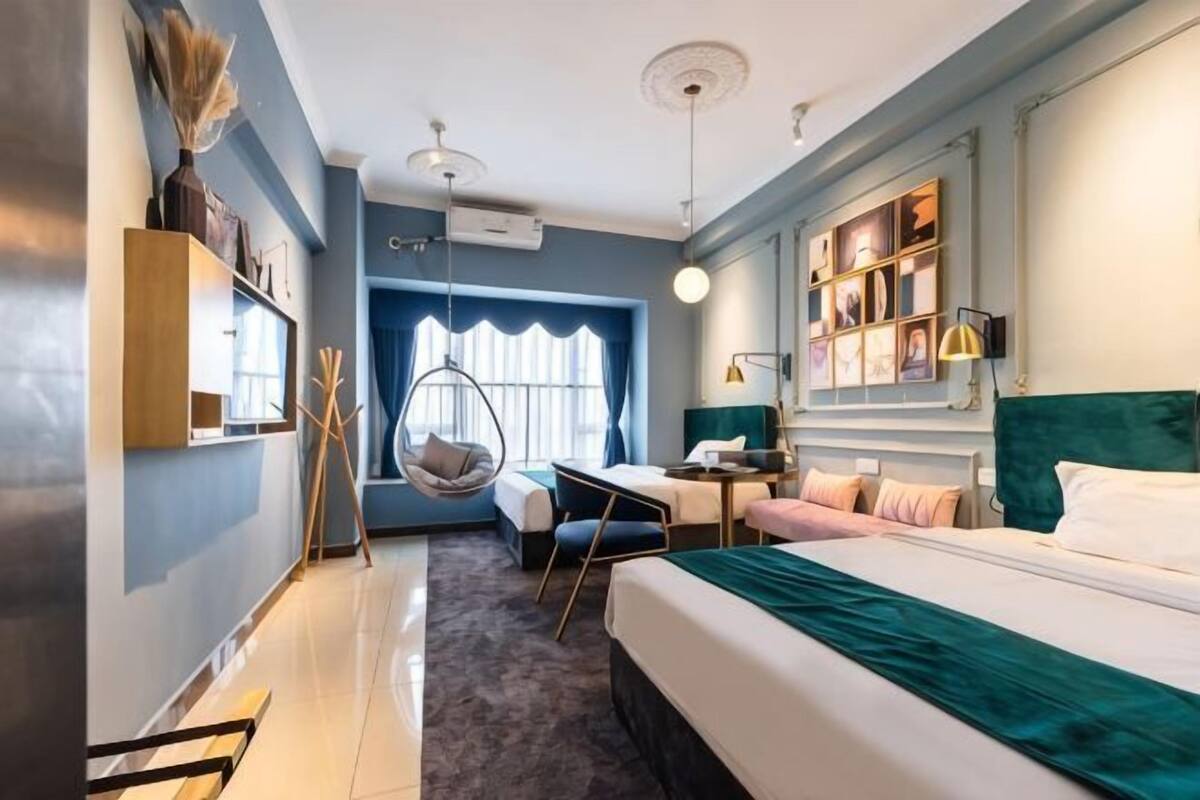 Ein Schlafzimmer mit Bett, Schreibtisch, Stuhl und einer Hängematte.