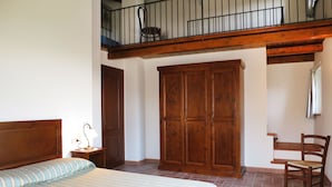 A bedroom with a bed, a wooden wardrobe, a chair, and a desk. - La Corte Bricca (Bilo C) by Interhome (Oltrepò Pavese)