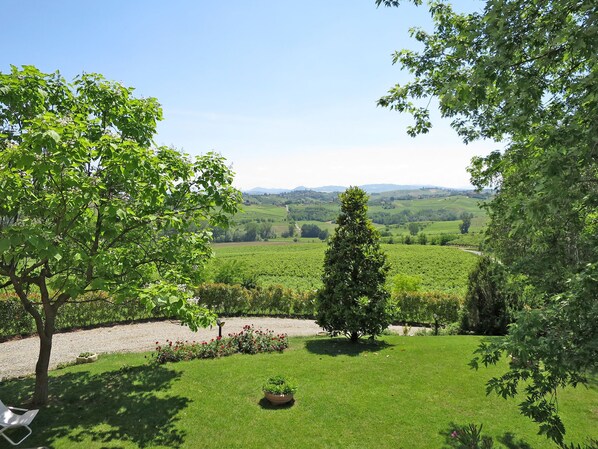 A well-maintained garden with a variety of trees, a lawn, and a gravel path. - Ca' del Vento by Interhome (Oltrepò Pavese)