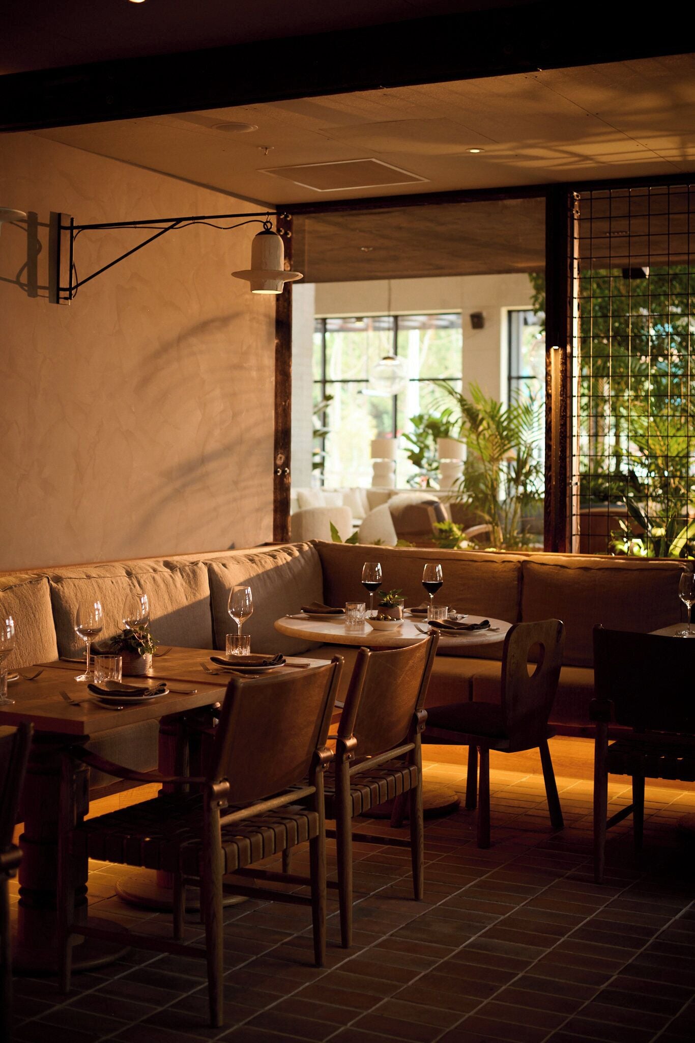 Un restaurant doté d’un espace salon accueillant, de tables avec des chaises et d’une vue par la fenêtre.