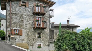 A stone building with balconies, a small window, and a sign that reads "CASAKIWI". - Casa Kiwi by Interhome (Cercino)