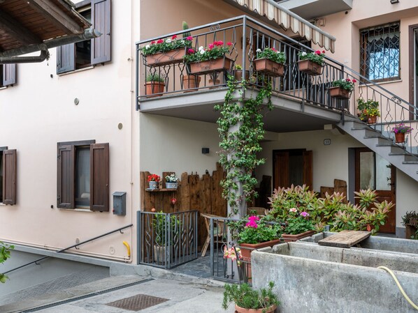 Un edificio de varios pisos con balcones decorados con macetas de plantas y flores.