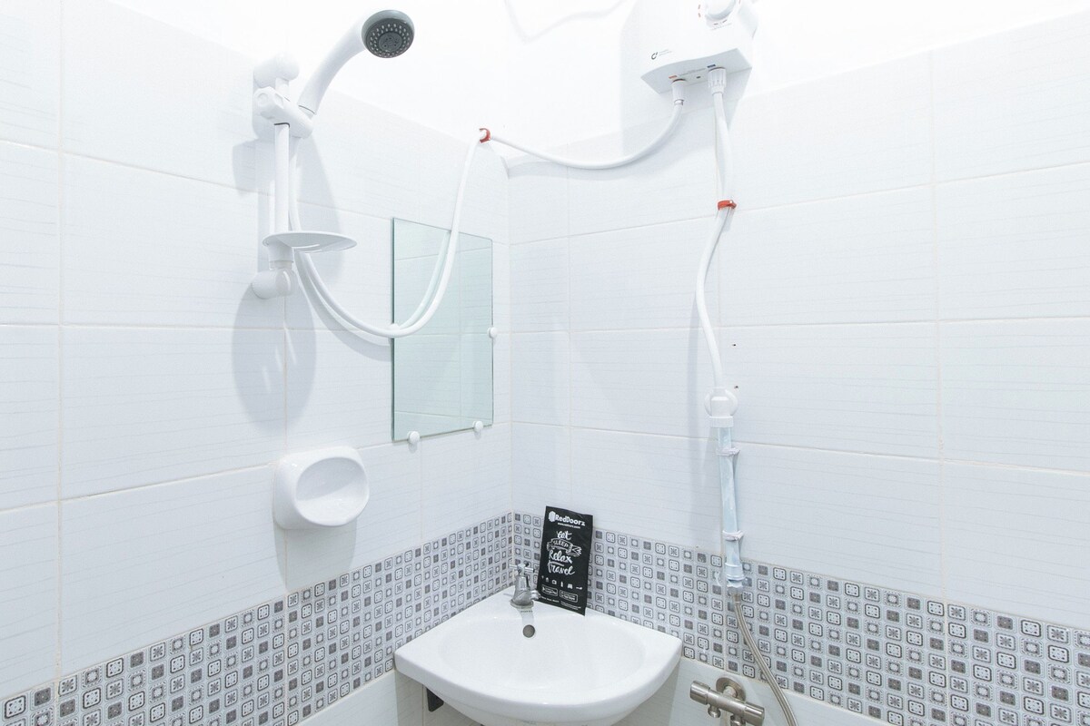 A bathroom with a toilet, sink, and shower.