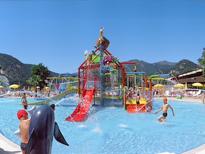 A water park with a large pool, slides, and play structures.