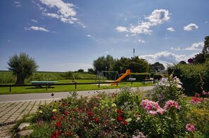 Un parc doté d’une aire de jeux, de tables de pique-nique et de parterres de fleurs.
