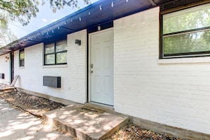 A white brick building with a white door marked 'B', a window, and a small porch area. - Cozy 2 Bedroom Apartment in Lawton Near Downtown (Lawton)