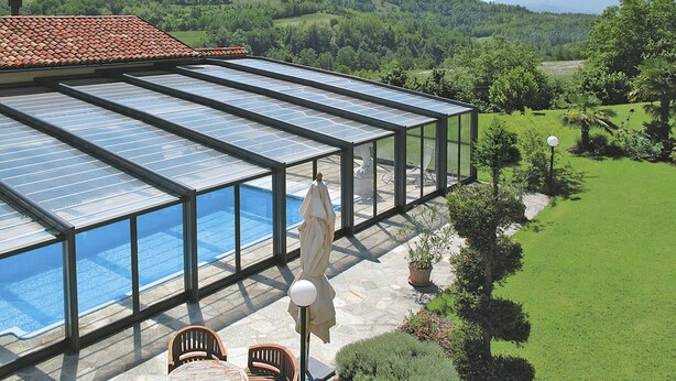 A glass-enclosed swimming pool with a view of a lush green landscape and hills. - Cascinotta by Interhome (Bastia Mondovì)
