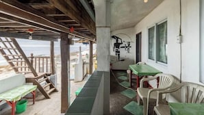 Ein Café direkt am Strand mit Terrassensitzgelegenheiten, einer Wandmalerei und Blick auf das Meer.