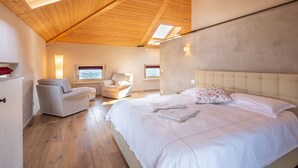 A bedroom with a large bed, a chair, a desk, and a window. - Villa Loreto by Interhome (Costigliole d'Asti)