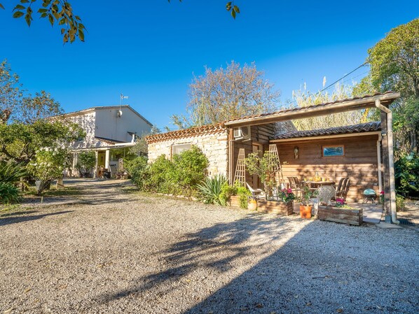 A rustic building with a gravel driveway and a wooden structure with a tiled roof. - Vacation home Magali by Interhome (Hyères)