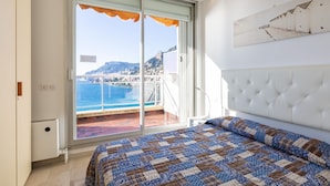 A bedroom with a large bed, a view of the sea, and a balcony. - Parc Massolin by Interhome (Roquebrune Cap Martin)