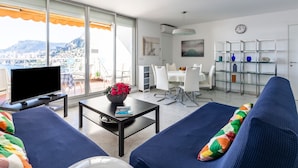 A modern living room with a TV, sofa, and dining area. - Parc Massolin by Interhome (Roquebrune Cap Martin)