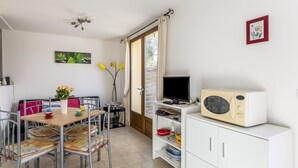 A compact living space with a dining area, a television, and a kitchenette. - La Petite Toscane by Interhome (Cabris)