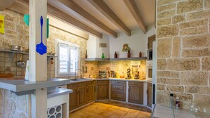 A kitchen with wooden cabinets, a tiled floor, and a window with curtains. - Labenne Océan by Interhome (Labenne)