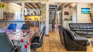 A spacious living area with a dining table, a leather sofa, and a kitchen in the background. - Labenne Océan by Interhome (Labenne)