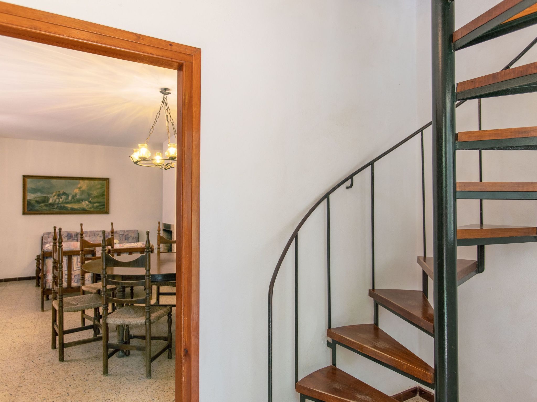 A staircase with wooden steps and metal railings, leading to an upper floor.