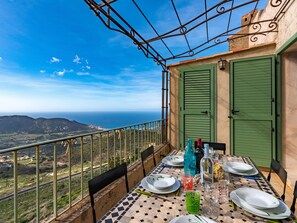 Une table dressée pour le dîner, avec vue sur la mer et les montagnes.