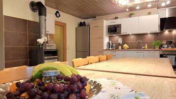 A modern kitchen with a dining table set for a meal, featuring a fruit platter.