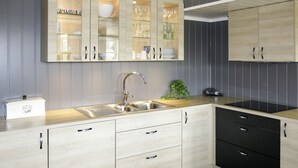 Une cuisine moderne dotée d’un îlot central, de meubles encastrés et d’un plan de travail noir.