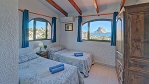 A room with two beds, a wooden wardrobe, and a view of a mountainous landscape. - Castillo by Interhome (Calpe/Calp)