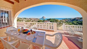 A terrace with a table set for four, overlooking a coastal town and the sea. - Castillo by Interhome (Calpe/Calp)