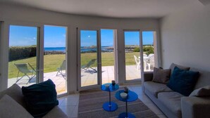 A spacious living room with a large sliding glass door leading to a patio with outdoor furniture.