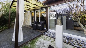 Une maison moderne dotée d’un patio couvert, de murs en pierre et d’une sculpture en pierre.