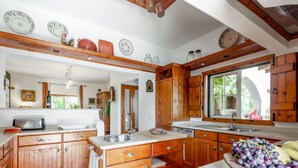 A kitchen with wooden cabinets, a sink, and a window.