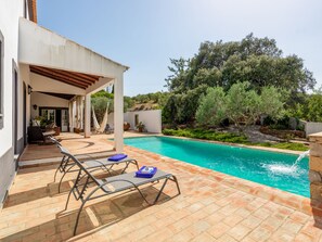 Ein Poolbereich mit Liegestühlen und einer Pergola.