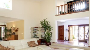 A spacious living room with a white sofa, a coffee table, and a staircase leading to an upper level. - Monte Meco by Interhome (Silves)