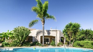 A pool surrounded by tropical plants and a building with a curved facade. - Monte Meco by Interhome (Silves)