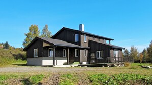 A two-story modern house with a large porch, a chimney, and a gravel driveway. - Gjefselykkja by Interhome (Skeikampen)
