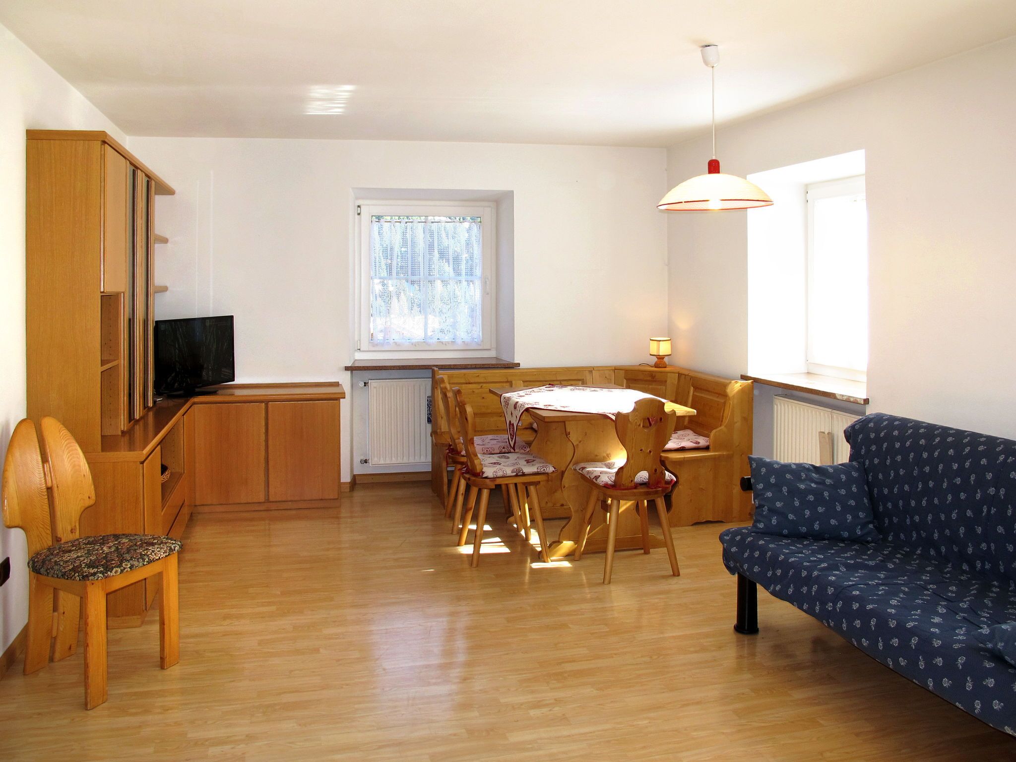 A compact living space with a dining area, a sofa, and a television.