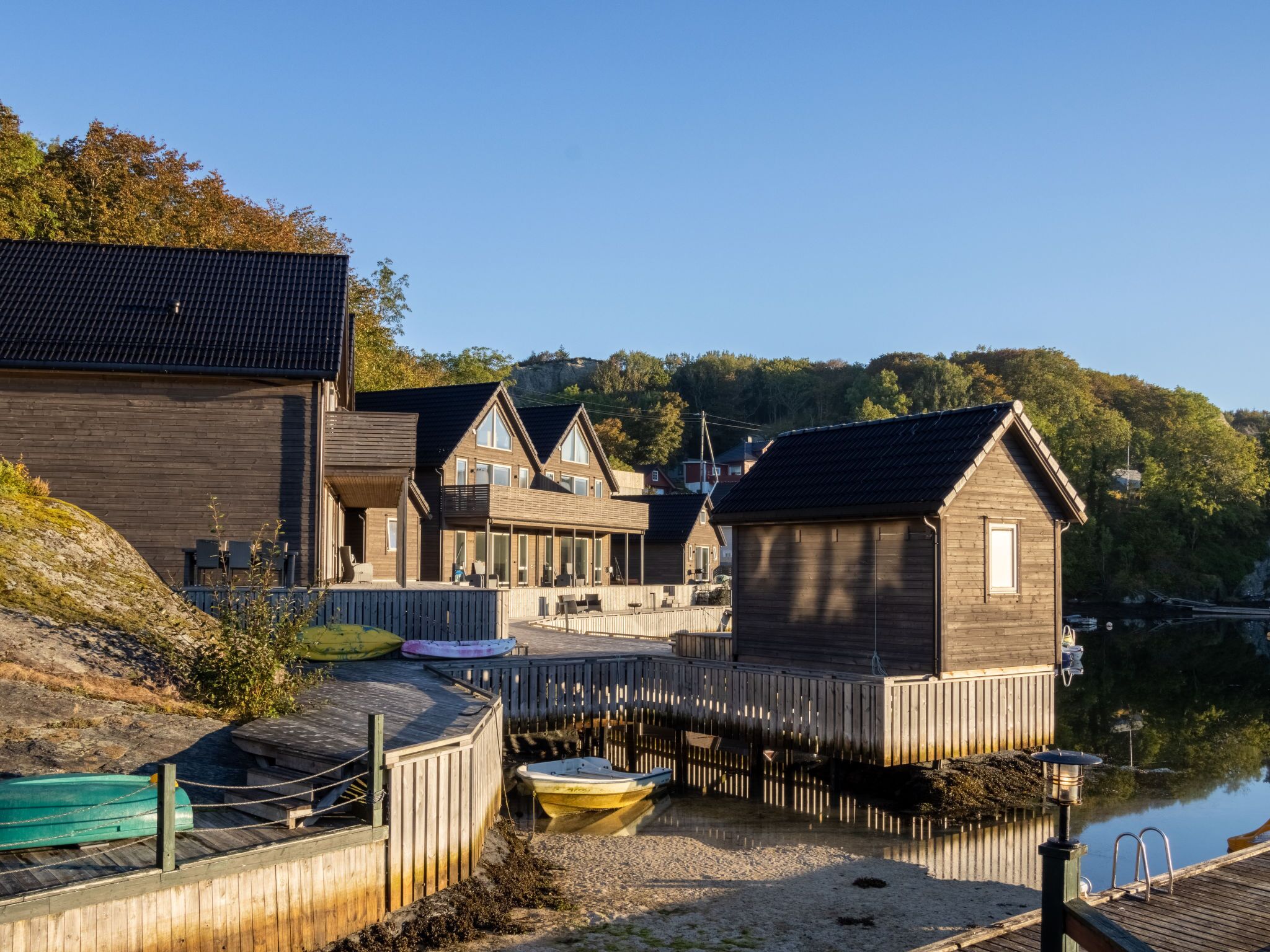 A waterfront property with wooden buildings, a dock, and a calm lake.