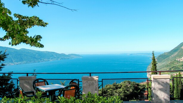 Terraço com mesa e cadeiras com vista para a costa.