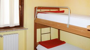 Uma cama beliche com janela e radiador.