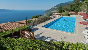 Piscina com vista para o mar e montanhas.