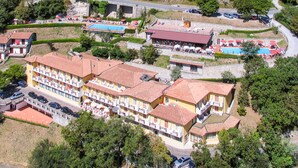 Um hotel grande com vários andares, piscinas ao ar livre e estacionamento.