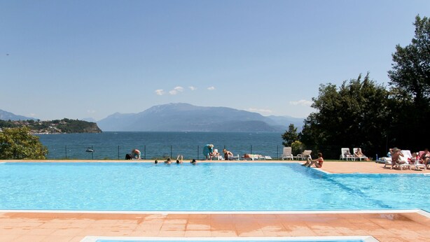 Una piscina con vistas al mar y a las montañas.