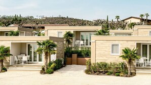 Une villa moderne dotée d’un patio, d’un espace salon extérieur et offrant une vue sur le paysage environnant.
