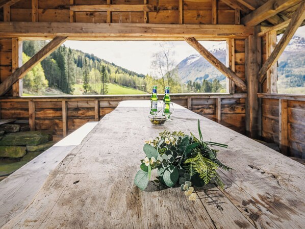 A wooden table with a view of mountains and a forest.