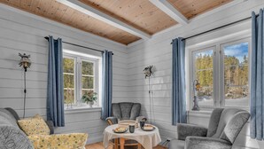 A cozy room with a wooden ceiling, white paneled walls, and a dining table set with plates and cups. - Vacation home Haven by Interhome (Birkeland)