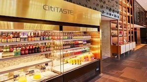 En godt oplyst kiosk med drikkevarer og et 'CitiTaste' skilt.