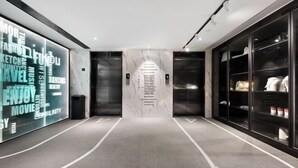 Et moderne elevatorområde med marmorvægge og et rent, minimalistisk design.